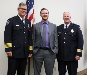 Person smiling with two other people in uniforms