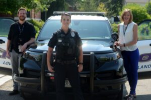 Police officers standing around police car