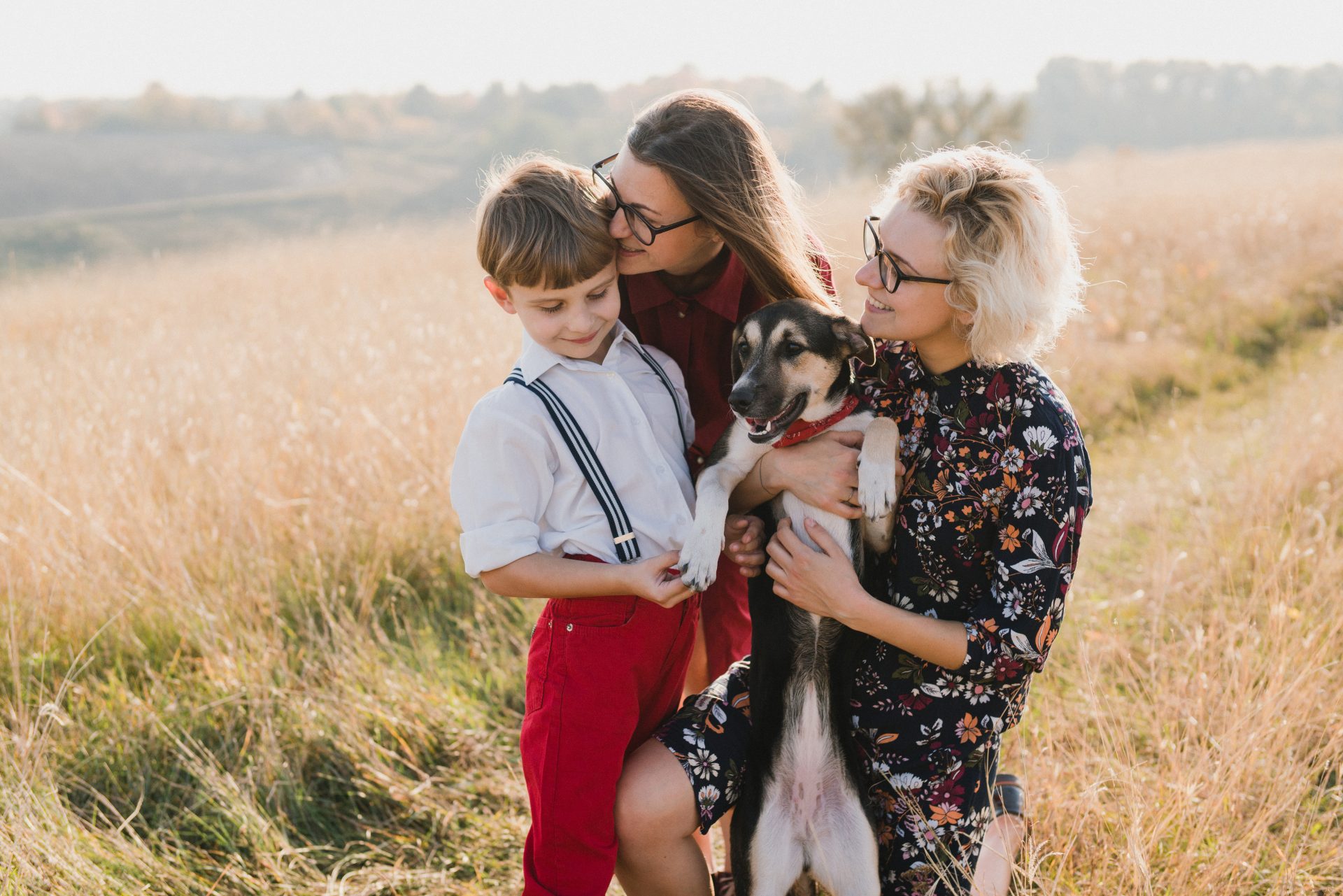 two women in a photoshoot with their child and dog