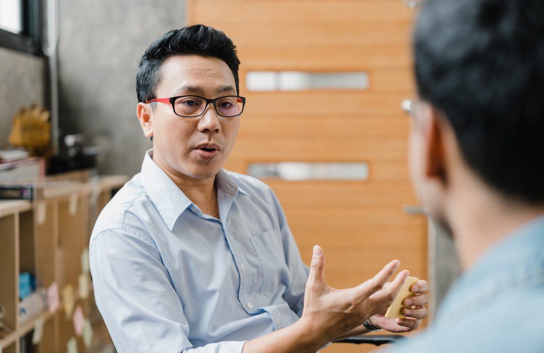 Two people having a conversation in an office