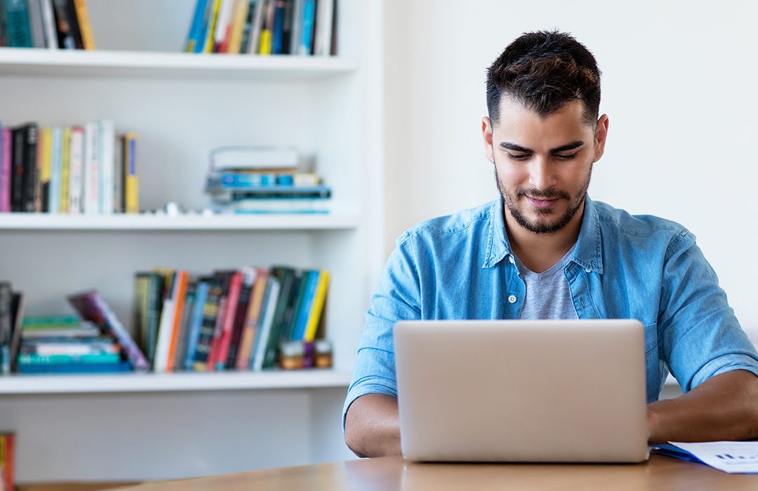 Man taking notes on laptop