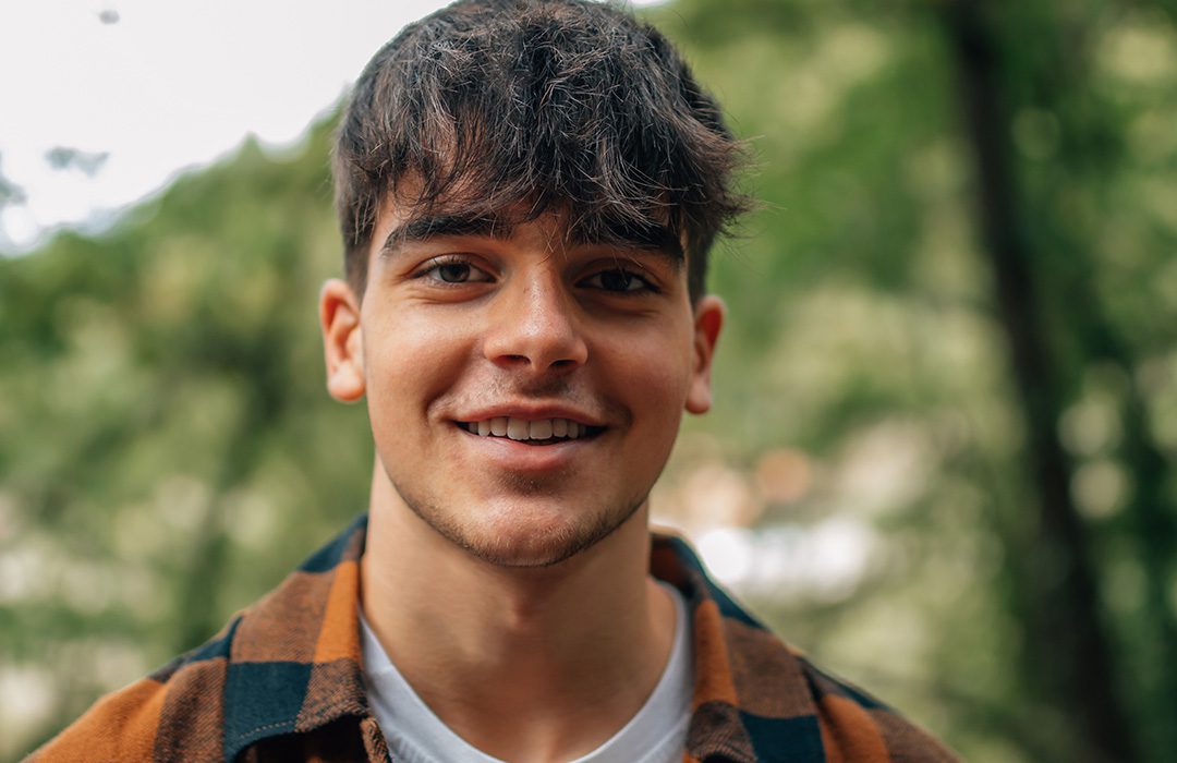 young person smiling outside