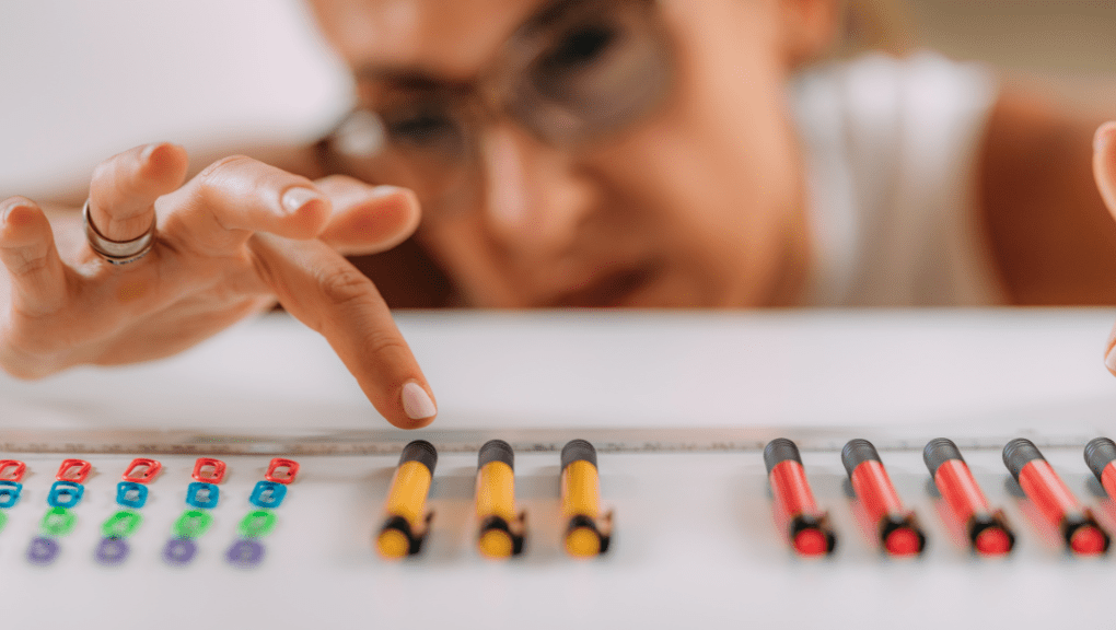 woman categorizing pens by color