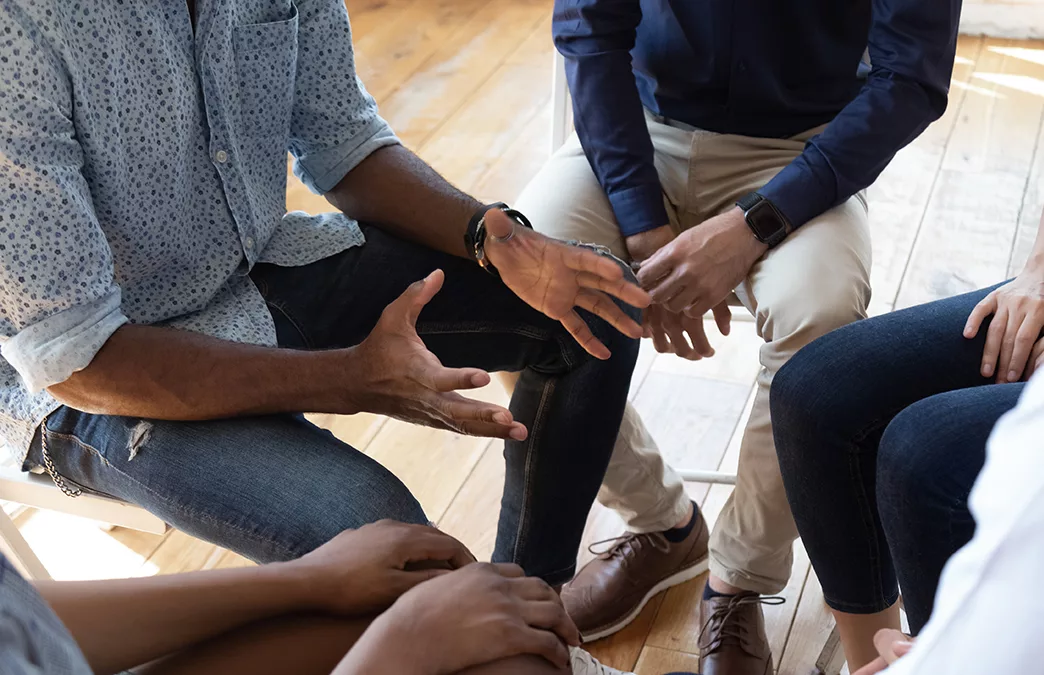 close up of people sitting and talking in a circle