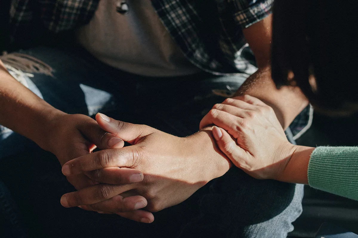 close up of person putting a hand on another persons arm