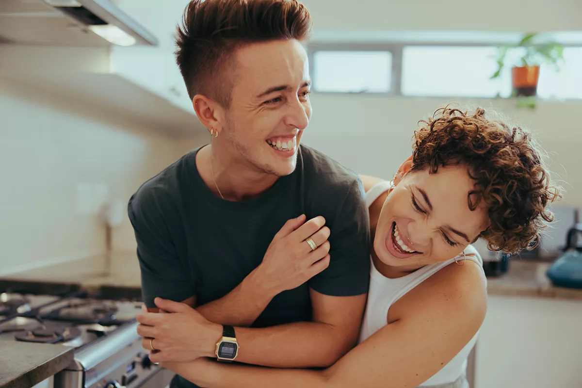 couple hugging and laughing at home