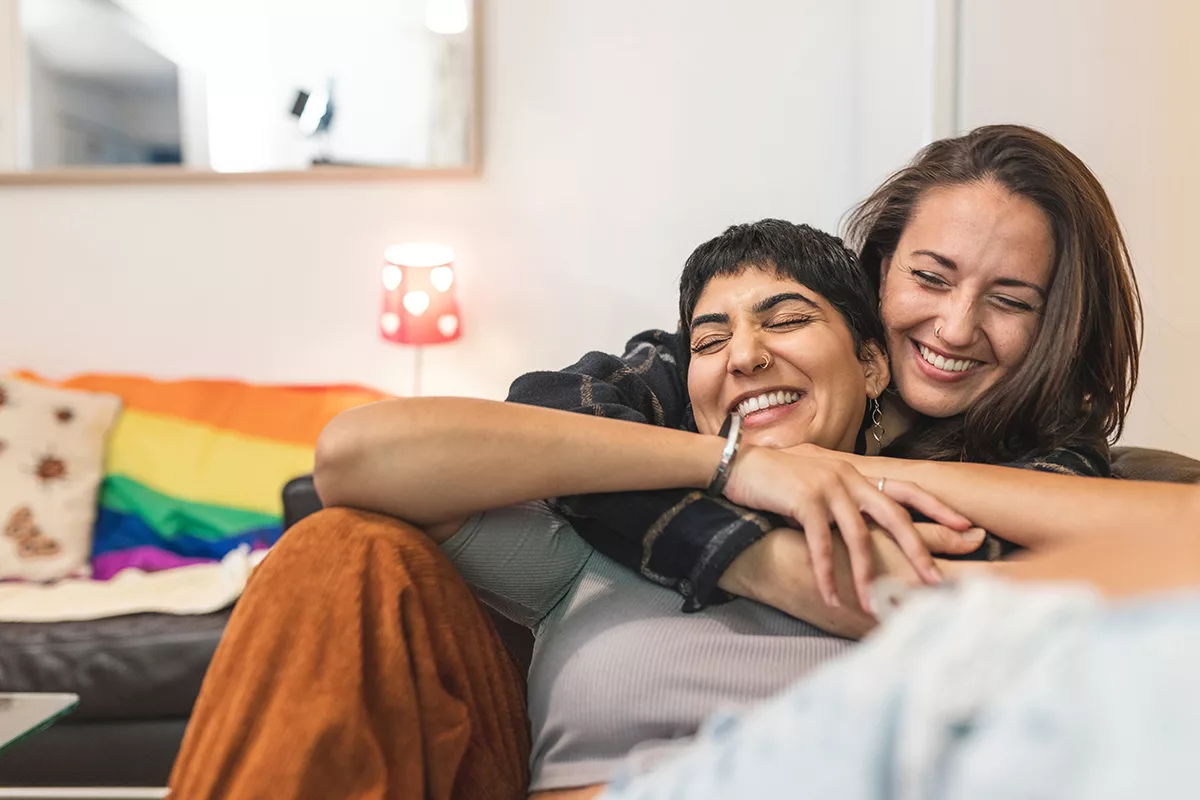 couple of people hugging on a couch