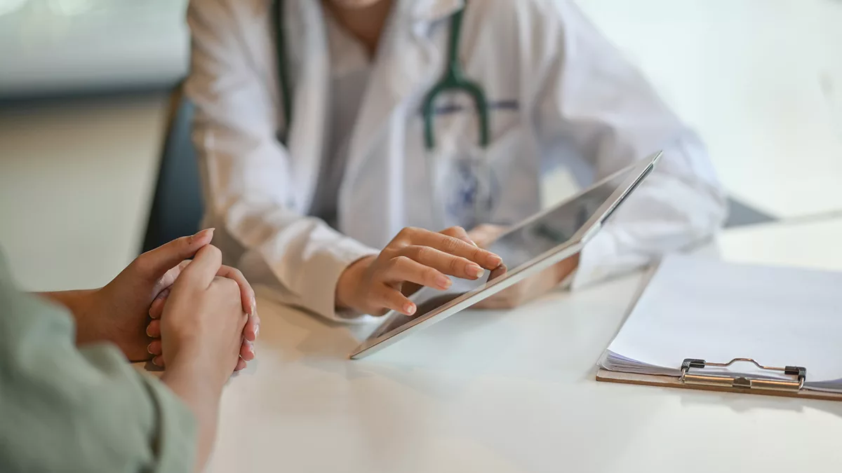 doctor with clipboard talking to patient