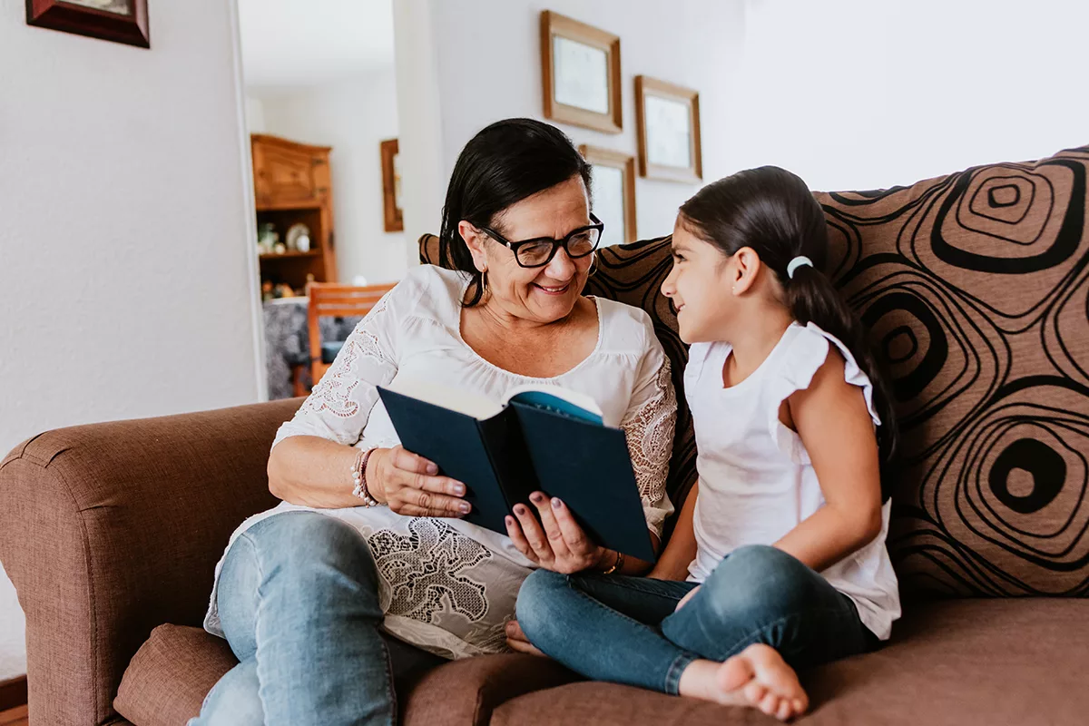 grandmother and granddaughter reading a book together