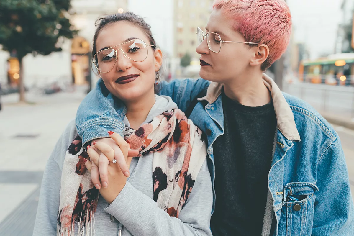 two people with arms around each other smiling